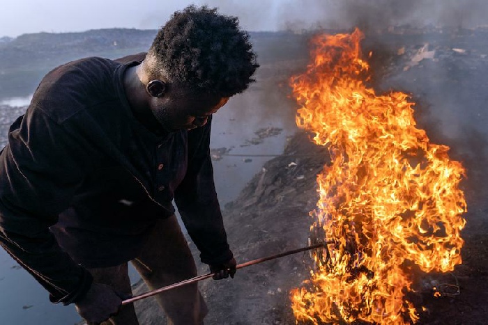 Old Fadama, Accra, Ghana, 9 février 2023. Simon Aniah, 24 ans, brûle des câbles électriques usagés pour récupérer du cuivre © Muntaka Chasant pour la Fondation Carmignac